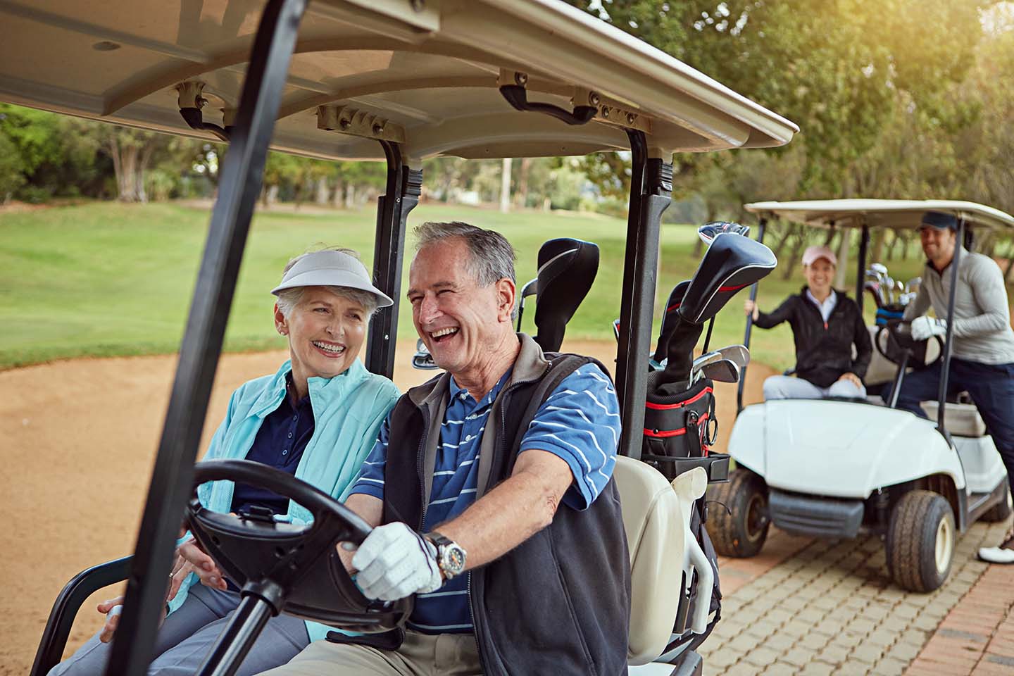 senior couple in golf cart enjoying retirement