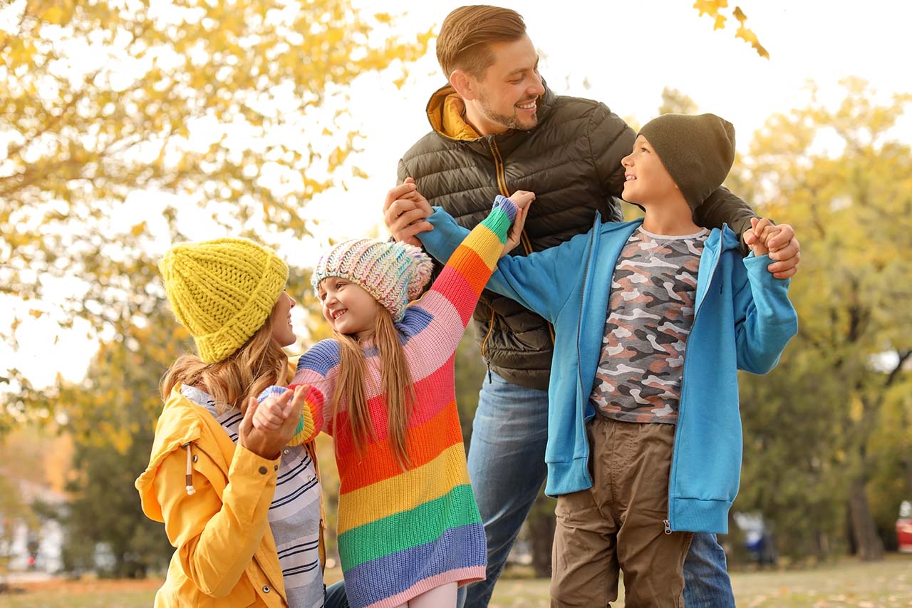 parents playing with their children outside in Autumn